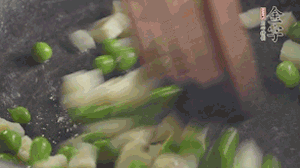 鍋中油7成熱時，入青豆、筍丁翻炒，然后加糯米飯加鹽均勻翻炒。