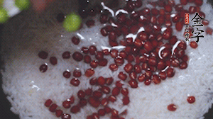 將炒好的食材和大米、紅豆一起放進(jìn)電飯鍋煮。