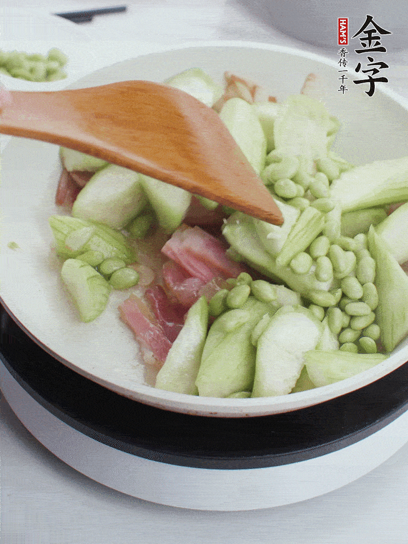 依次下絲瓜、青豆翻炒，炒至絲瓜打蔫縮小。