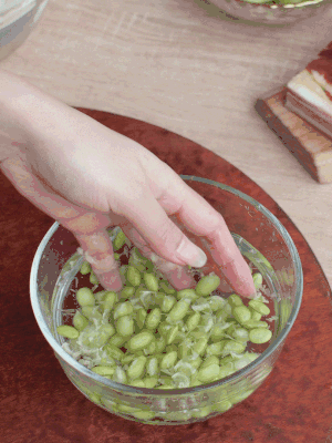 青豆剝殼，搓去外衣。