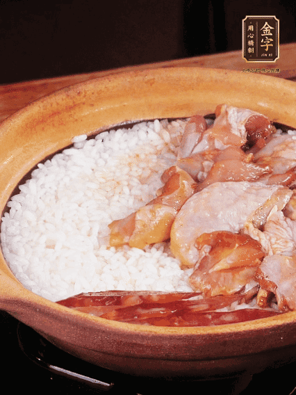 煮到椰子水微微收干轉(zhuǎn)小火，快速均勻鋪上雞肉、金字香腸