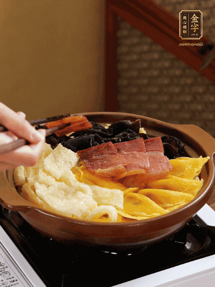 砂鍋底部鋪上娃娃菜，依次擺上肉皮、蛋餃、黑木耳、火腿